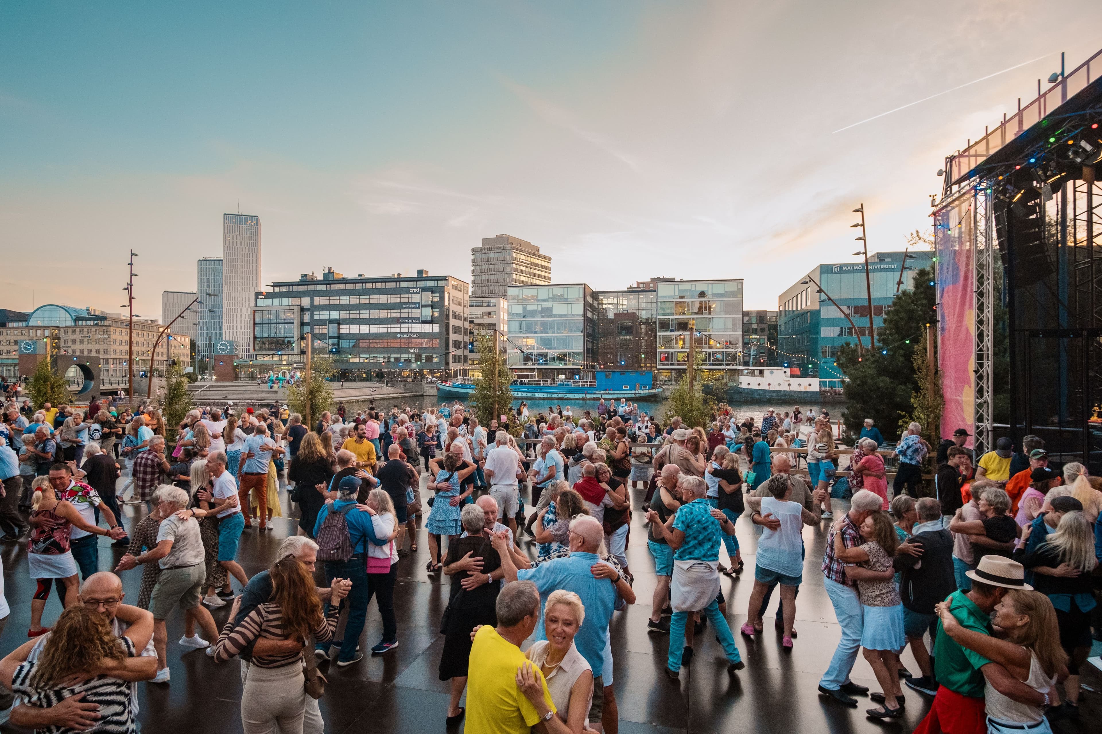 Människor dansar i par på ett dansgolv utomhus i stadsmiljö under Malmöfestivalen.